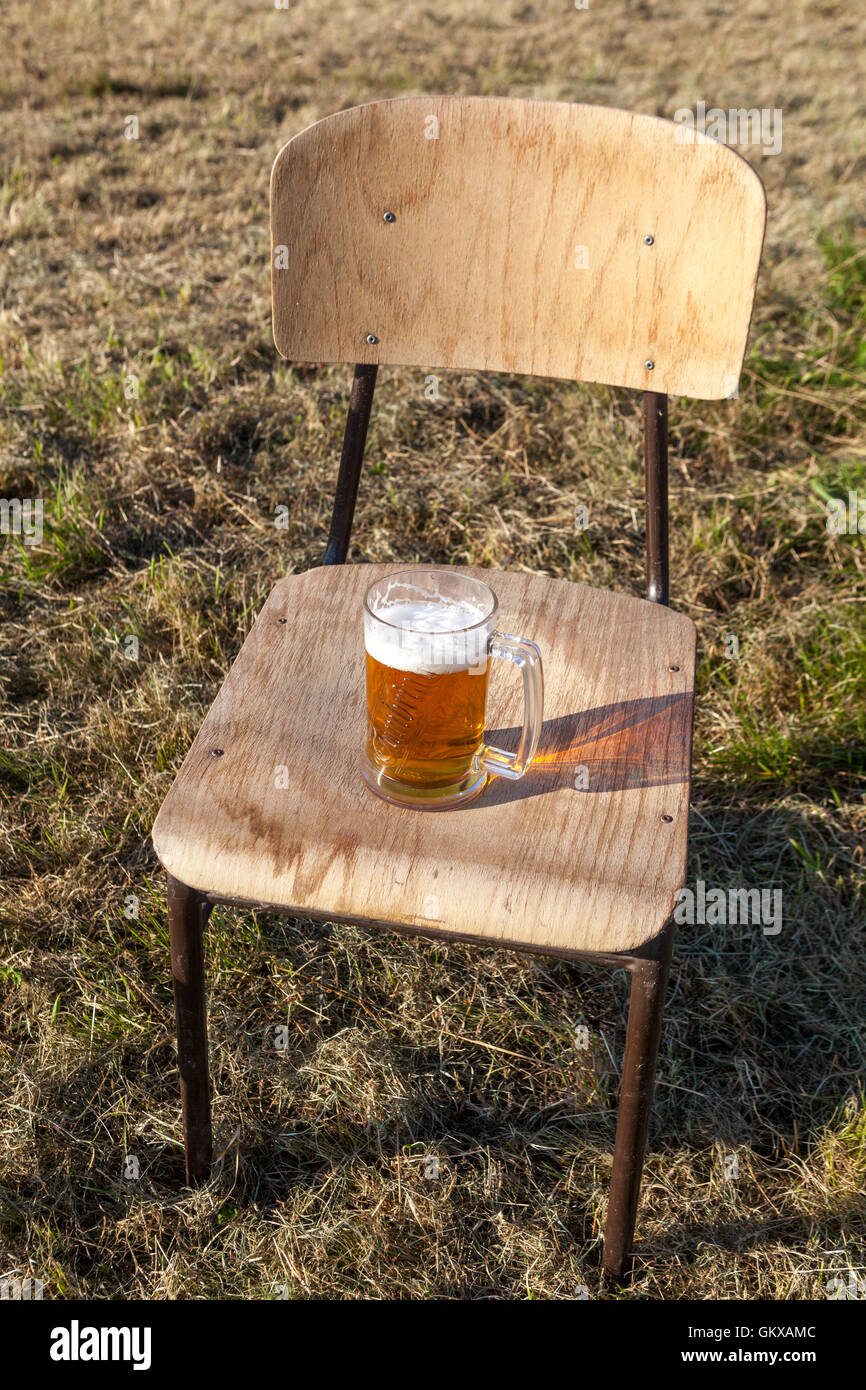 Bicchiere di birra su una sedia Foto Stock