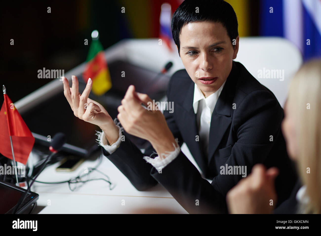 Esperto politico femmina parlando a un collega dal G7 Foto Stock