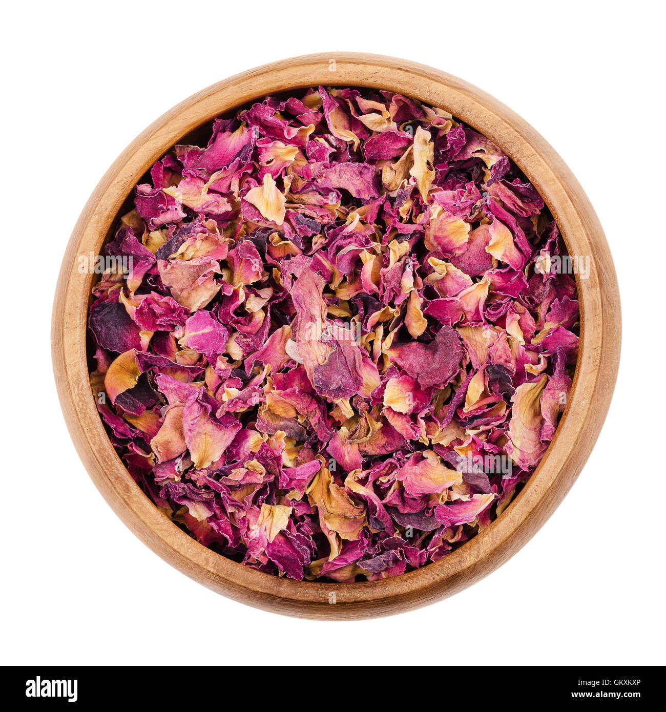 Essiccati petali di rosa in una ciotola di legno su sfondo bianco. Utilizzato per profumi, cosmetici, tè e bagni. Foto Stock