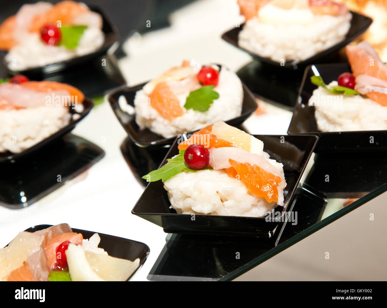 Finger food con salmone affumicato, pesce crudo, limone e ribes nero Foto Stock