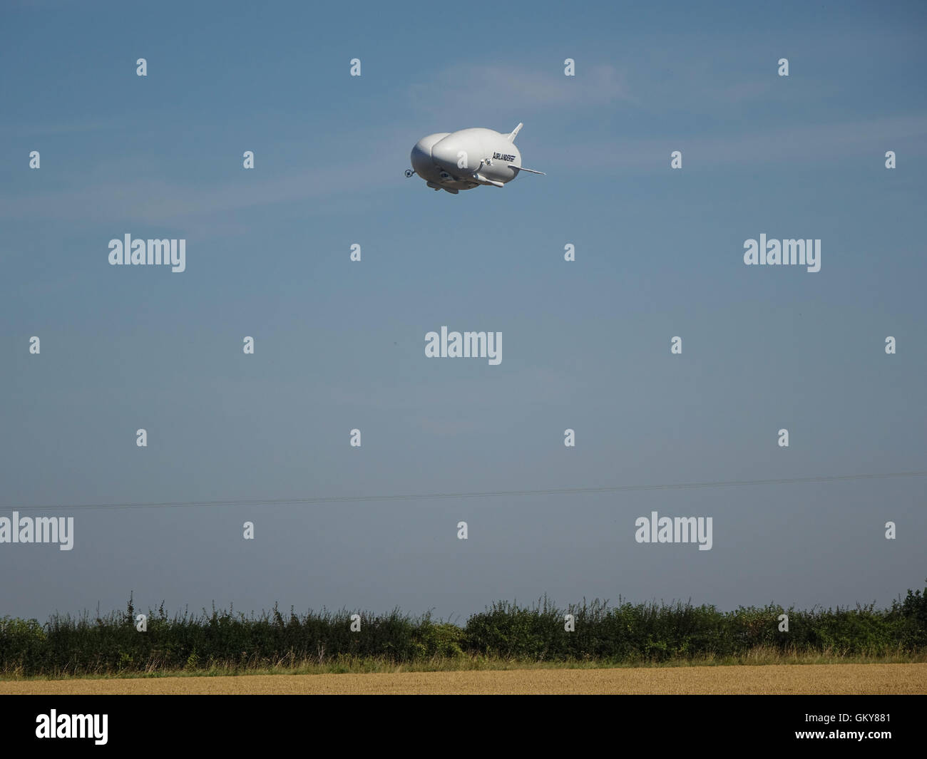 Bedfordshire, Regno Unito. 24 Agosto, 2016 l'aria ibride Veicoli (HAV) Airlander 10 subendo i voli di collaudo al di sopra del Bedfordshire e Hertfordshire campagna. Tenuto fuori dal centro storico della RAF Cardington hangar è un ampio a scafo dirigibile con aletta ausiliaria e superfici di coda, vola utilizzando sia aerostatico e ascensore aerodinamico. Alimentato da quattro diesel-motore azionato eliche intubate, è il più grande velivolo oggi. Entro la prossima ora questo aeromobile crash aveva atterrato presso la stazione base, causando un danno per il cockpit. Photo credit: Mick Flynn/Alamy Live News Foto Stock