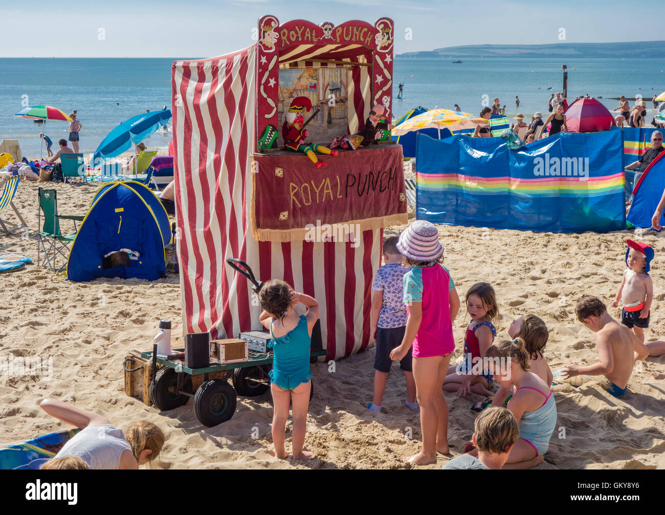 I bambini guardando un punzone e Judy visualizza sulla spiaggia di Bournemouth Dorset, Regno Unito Foto Stock