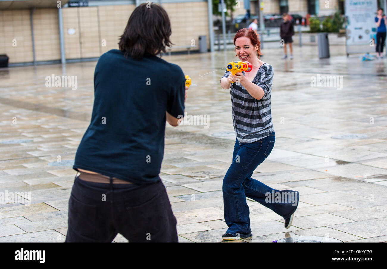 Bristol, Regno Unito. 24 Agosto, 2016. Un massiccio acqua lotta ha avuto luogo a Bristol's Millennium Square questa sera. Decine di persone hanno utilizzato le pistole ad acqua, bottiglie, palloncini e benne per attaccare ogni altro con acqua. Avon e Somerset Vigili del Fuoco sono arrivati con un motore Fire a partecipare. Hanno partecipato anche il Bristol l' ex-eletto sindaco, George Ferguson. L evento è stato organizzato per raccogliere fondi per un senzatetto YMCA hostel. Bristol, Regno Unito. 24 agosto 2016. Credito: Fotografia Redorbital/Alamy Live News Foto Stock