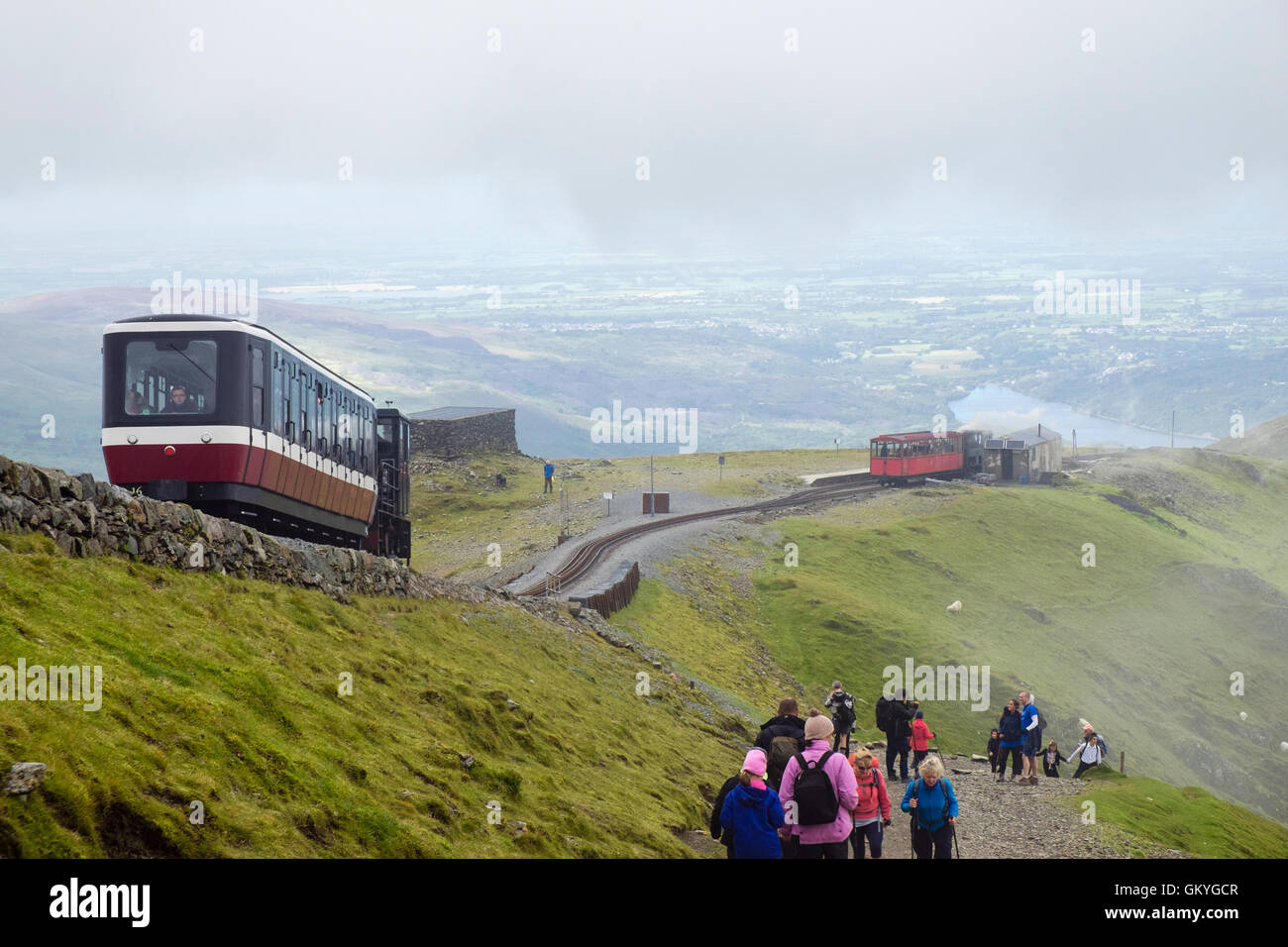 Il treno scendendo su Snowdon Mountain Railway Clogwyn sopra la stazione e la gente che camminava sul percorso di Llanberis su Mt Snowdon in Snowdonia (Eryri). Wales UK Foto Stock