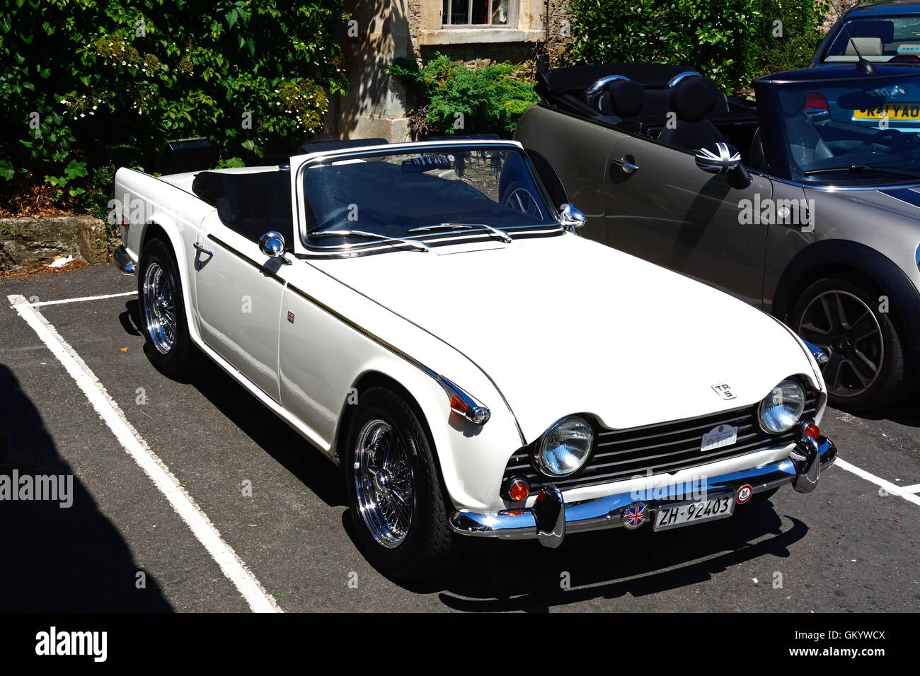 Un bianco soft top Triumph TR5 parcheggiato nel villaggio, Castle Combe, Wiltshire, Inghilterra, Regno Unito, Europa occidentale. Foto Stock