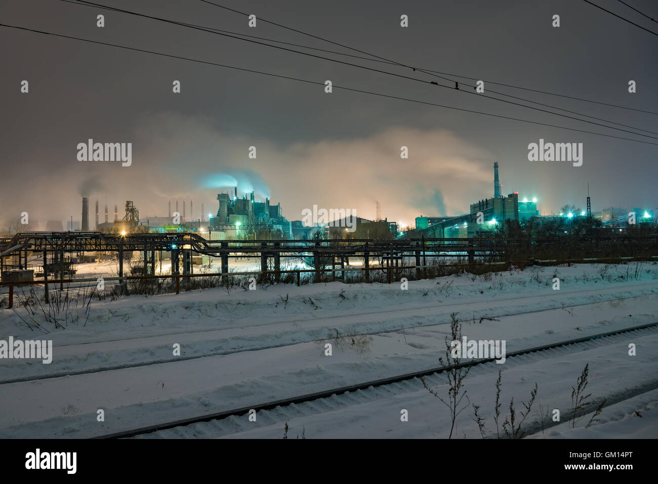 La stazione di potenza con Steam cloud soffiata dal vento in un freddo inverno stellato di notte Foto Stock