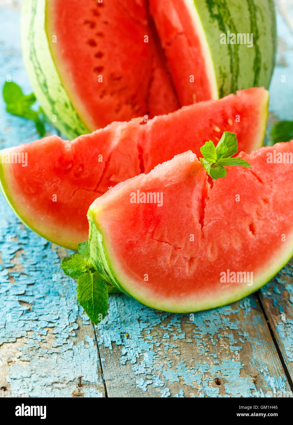 Anguria fresco tagliato a fette con la menta vicino sul tavolo Foto Stock