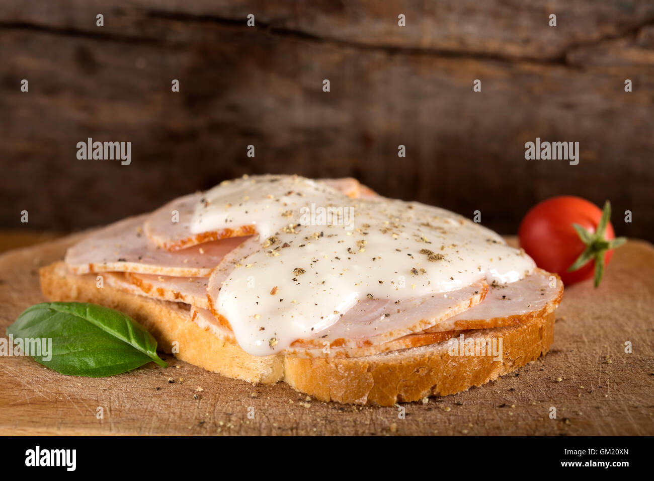 Aprire il fronte di pollo sandwich di prosciutto con salsa di aglio su sfondo di legno Foto Stock
