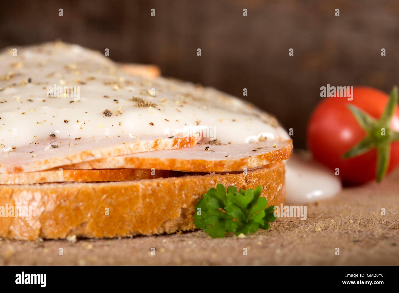 Aprire il fronte di pollo sandwich di prosciutto con salsa di aglio su sfondo di legno Foto Stock
