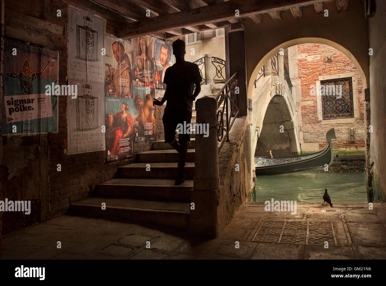 Silhouette maschio attraversando ponte in vicolo, Venezia Italia Foto Stock