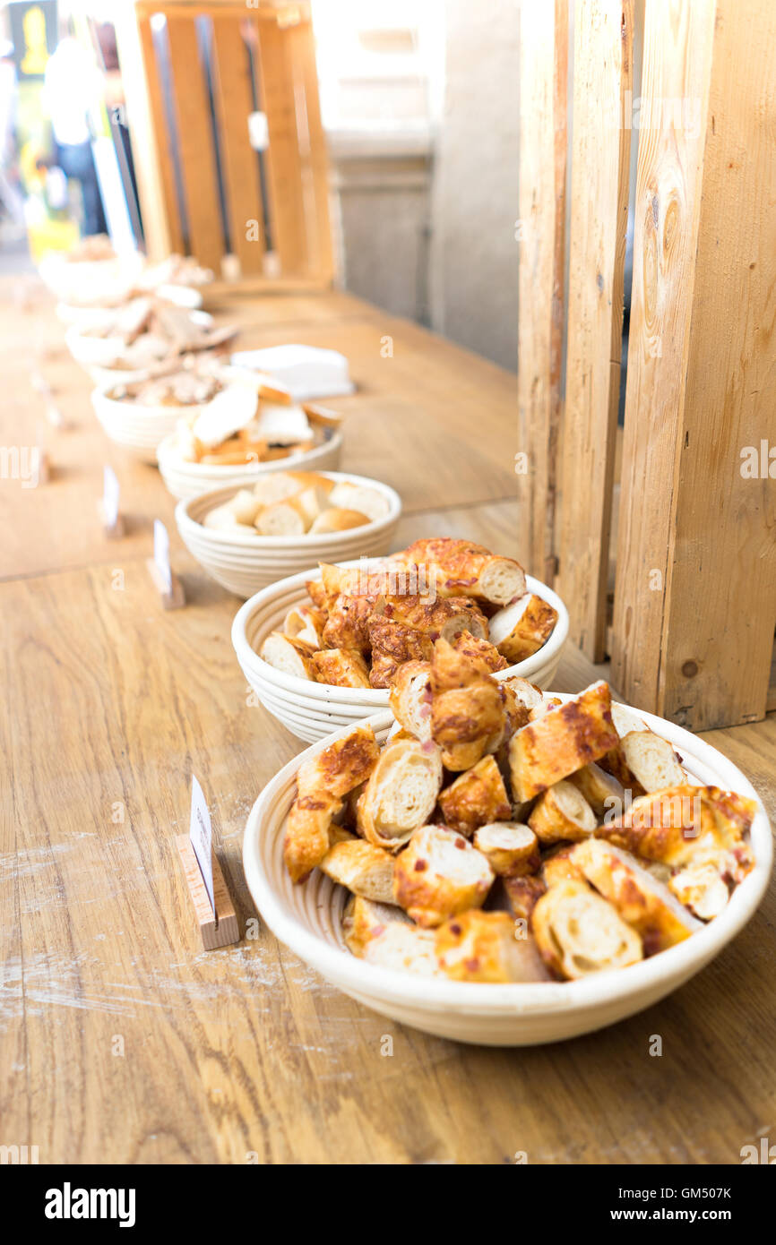 Diversi tipi di pane in una fila su un tavolo di legno a lunga tavola - Lange Tafel der Genusshauptstadt Foto Stock