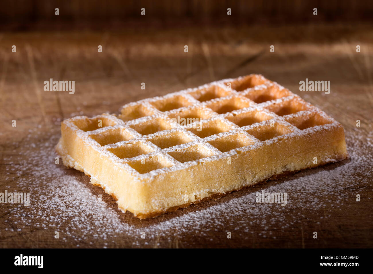 Waffle freschi con lo zucchero in polvere su un sfondo di legno Foto Stock