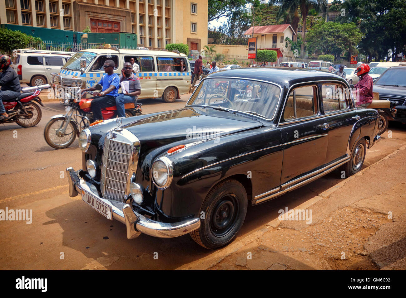 Un classico Mercedes Benz parcheggiato al di fuori di una strada trafficata a Kampala in Uganda. Foto Stock