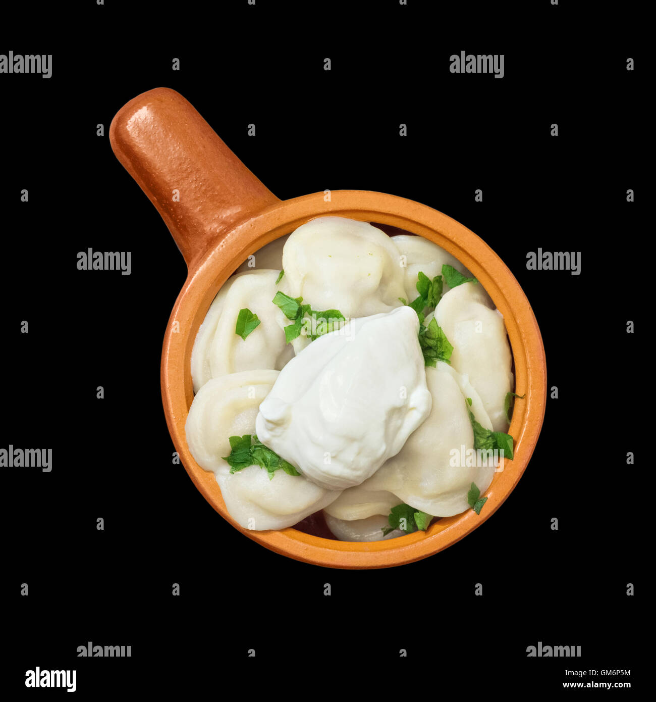 Gnocchi con verdi e panna acida su uno sfondo nero isolato Foto Stock