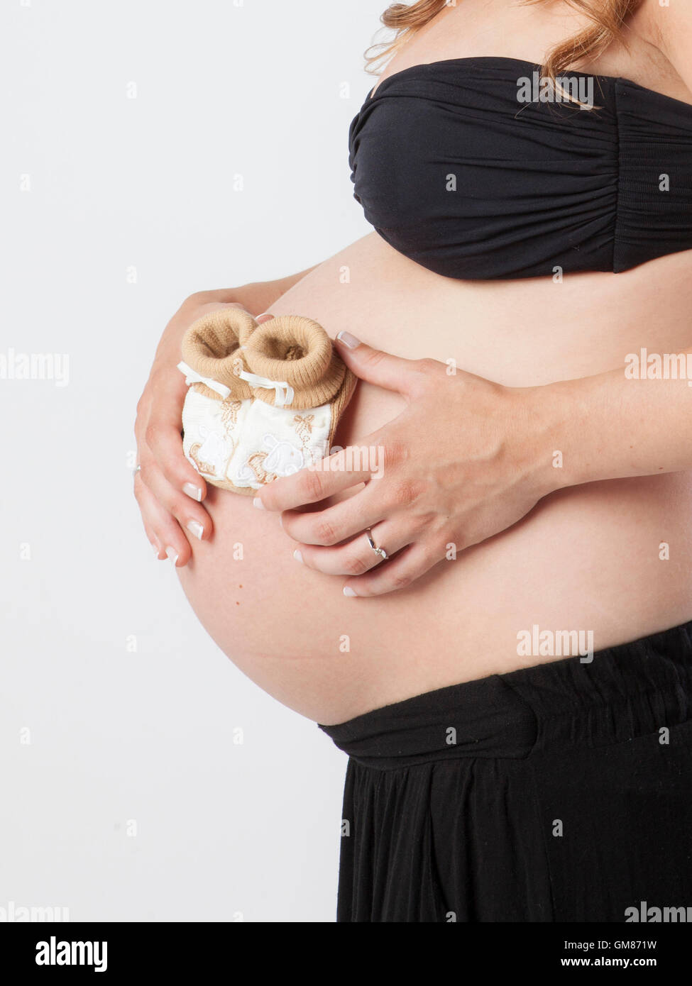 Donna incinta tenendo le sue mani sulla pancia bella Foto Stock