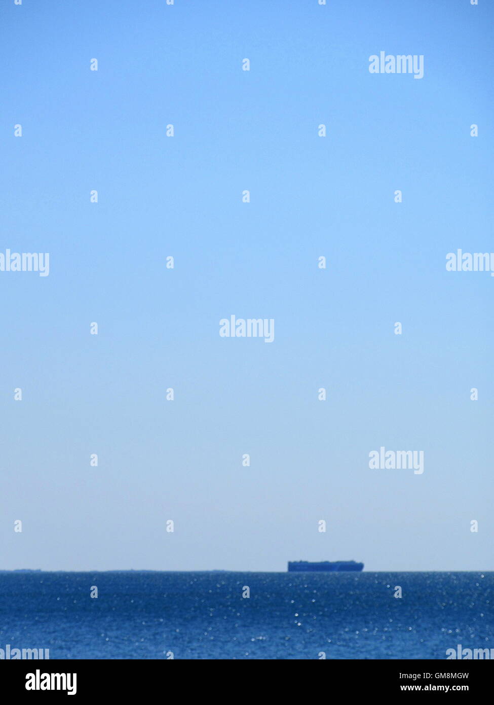 Telaio completo colpo di blu del mare e del cielo con la barca all'orizzonte Foto Stock