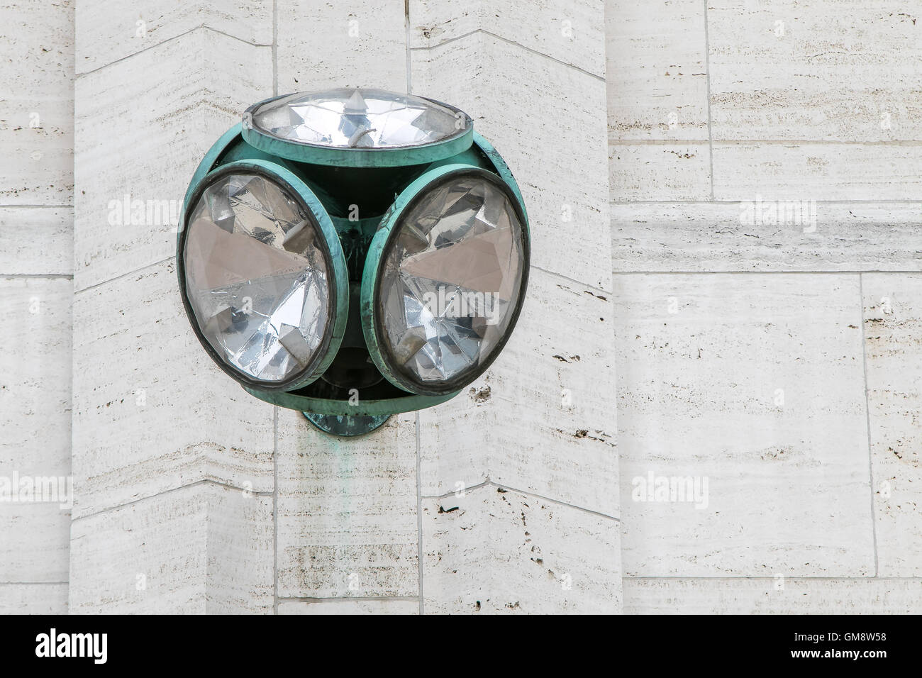 Una lampada di design insolito è montato su un lato esterno della parete edilizia Foto Stock
