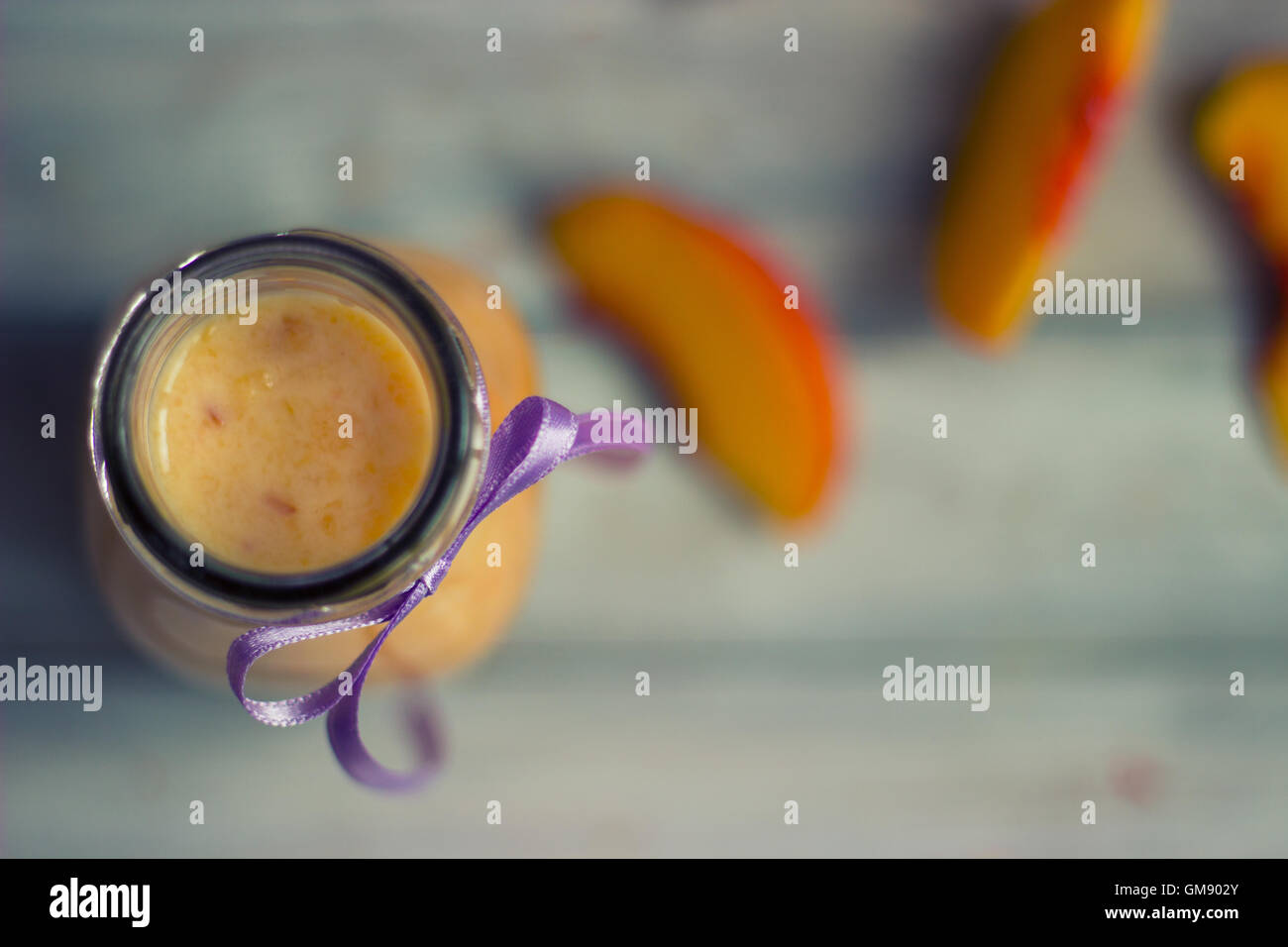 Pesche frullato e su sfondo di legno Foto Stock