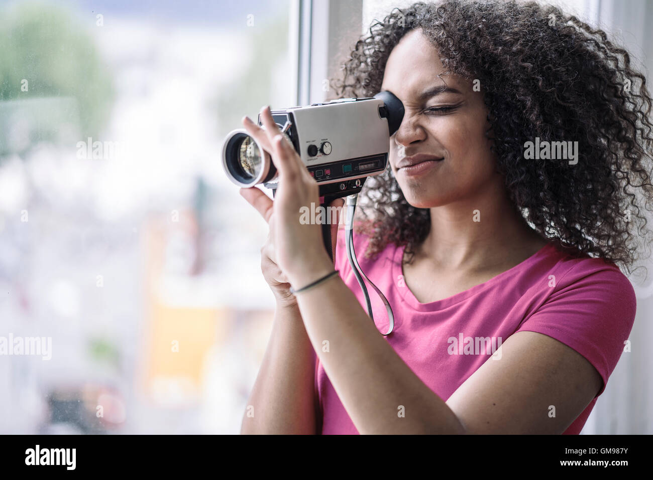 Giovane donna usando la vecchia scuola fotocamera Foto Stock