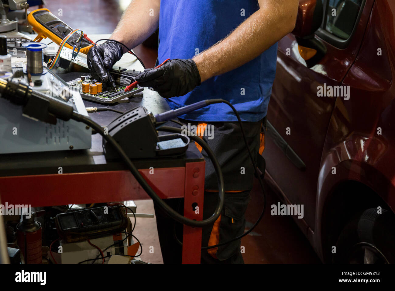 Il fissaggio meccanico di un sistema elettronico di parti di automobili nel suo laboratorio Foto Stock