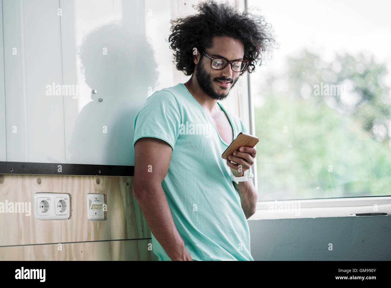 Giovane uomo in ufficio utilizzando smart phone Foto Stock
