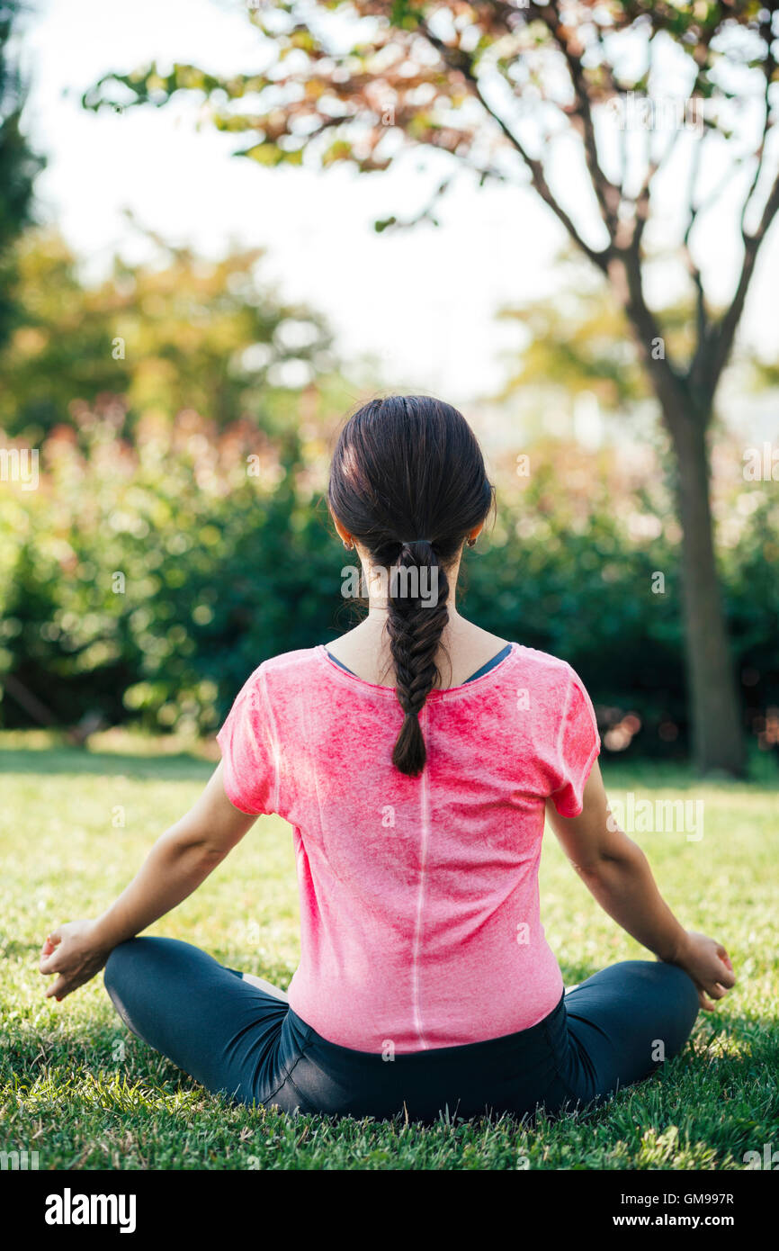 Giovane donna meditando in posizione di parcheggio Foto Stock