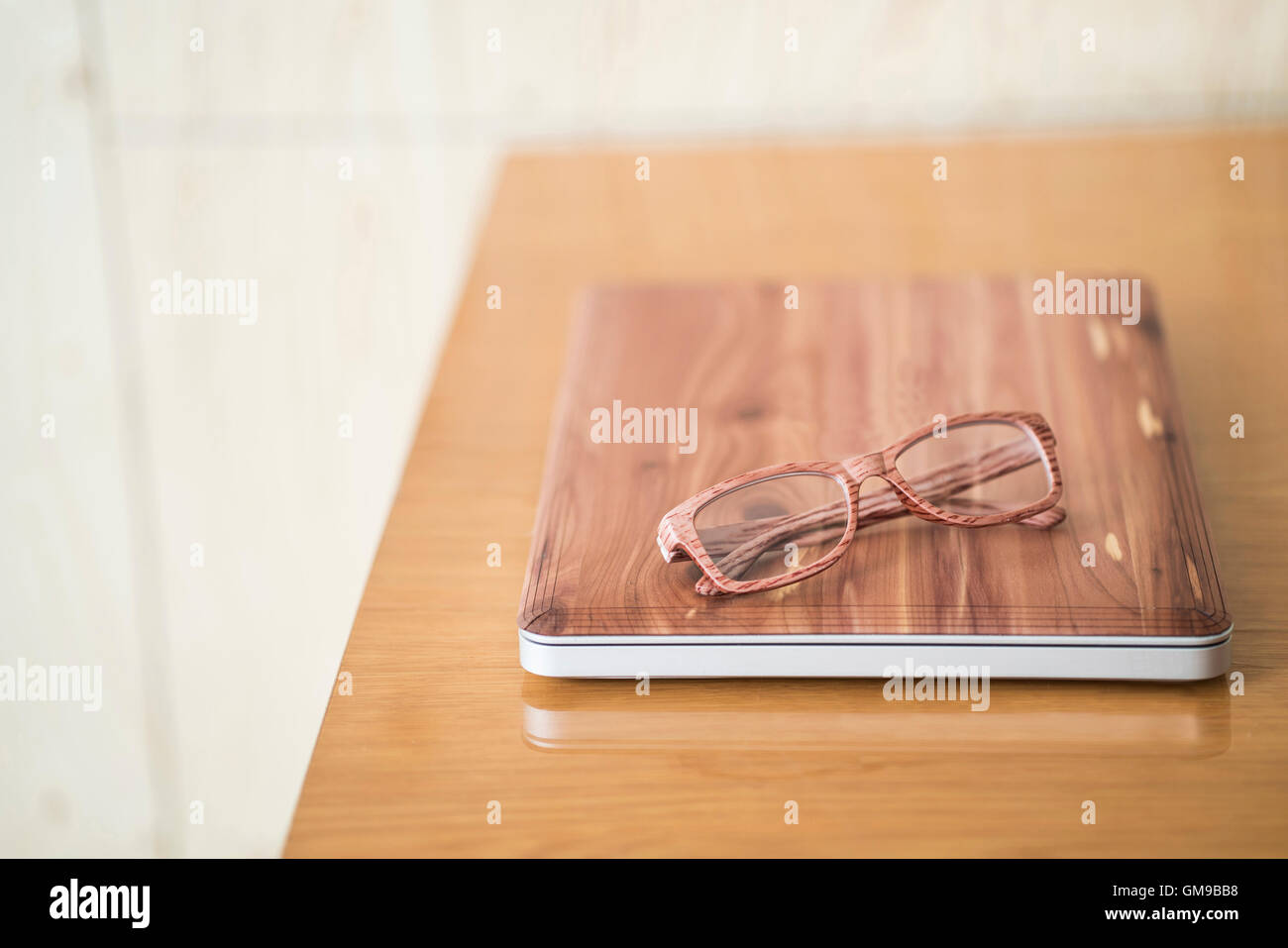Laptop in legno e bicchieri in legno sulla scrivania Foto Stock