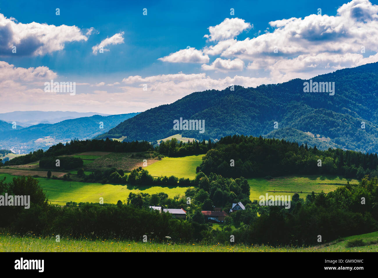 Edifici agricoli tra il Beskid Sądecki montagne illuminate dal sole al mattino Foto Stock