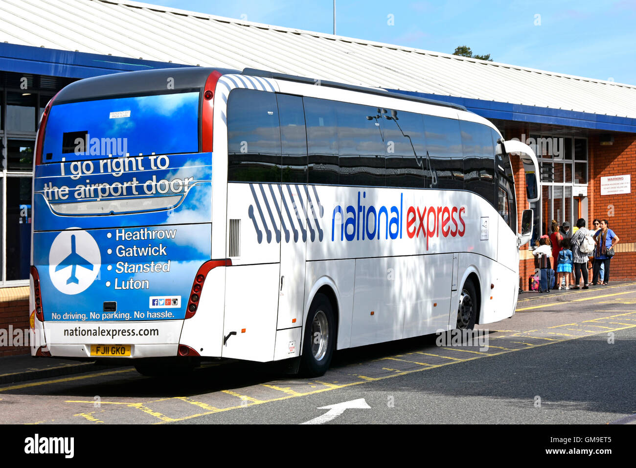 La National Express UK autobus che arrivano a Coventry 'pool' di Prato West Midlands stazione degli autobus con la pubblicità per airport percorsi sul retro del bus Inghilterra Foto Stock