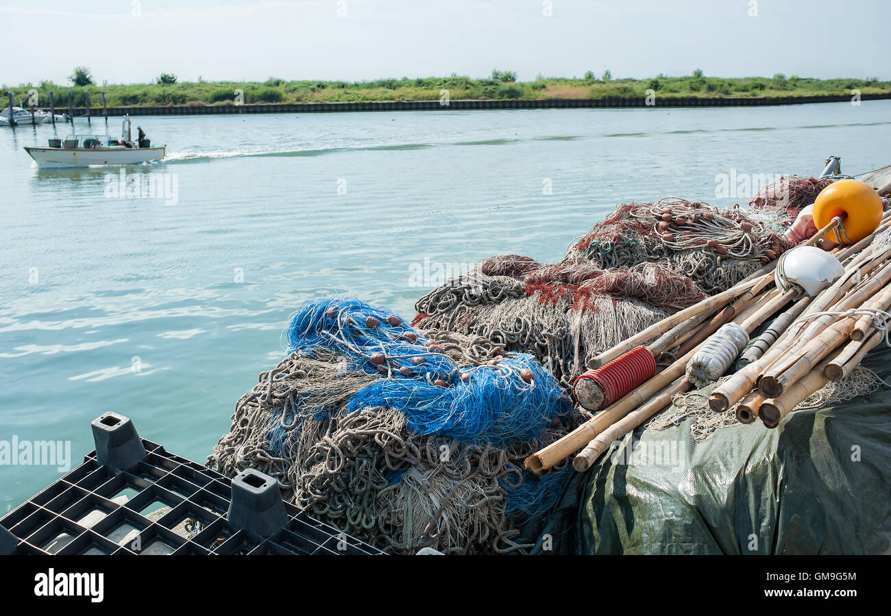 Le reti da pesca impilati in una fila sul molo Foto Stock