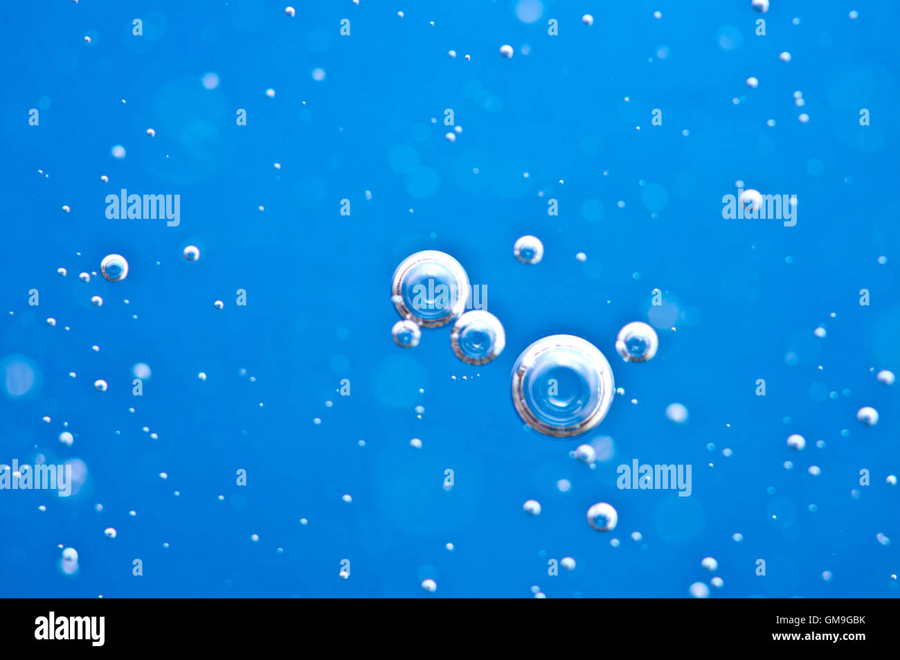Close-up le bolle sotto acqua su sfondo blu. Macro. Concetto chiaro naturale dell'acqua. Foto Stock