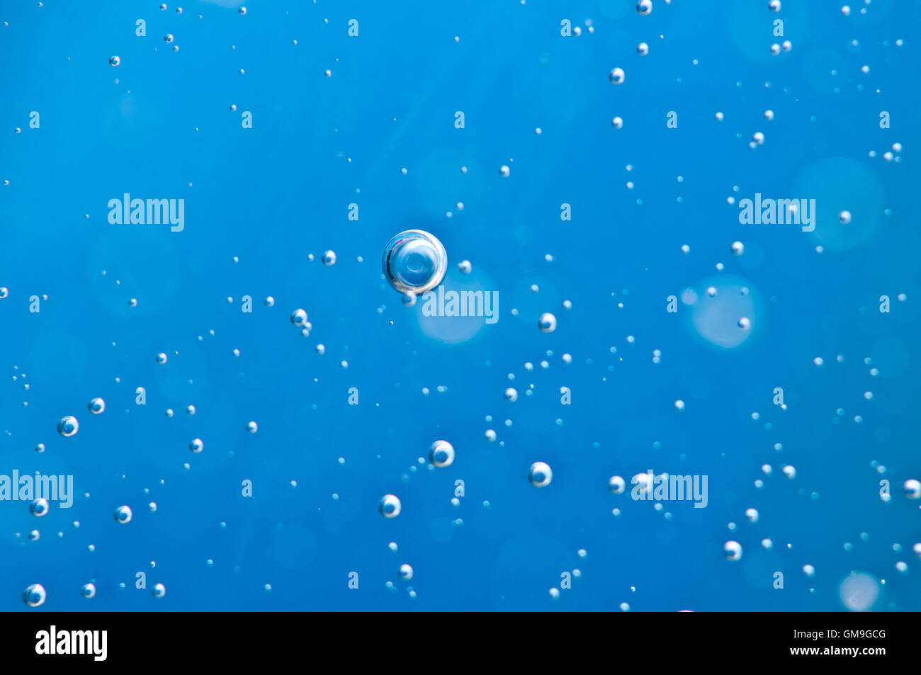 Close-up le bolle sotto acqua su sfondo blu. Macro. Concetto naturale acqua chiara Foto Stock