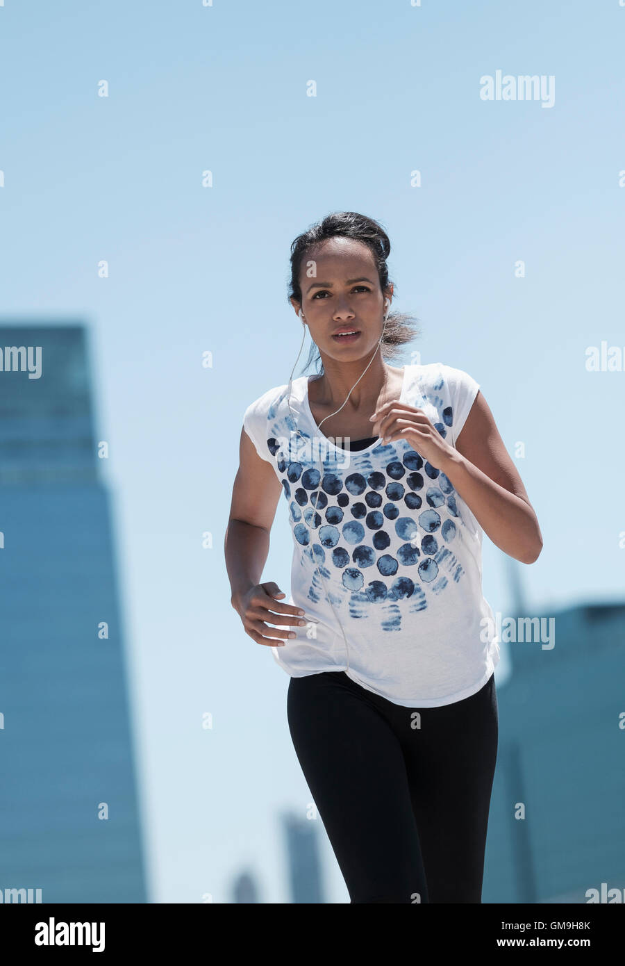 Vista frontale della metà donna adulta jogging in città Foto Stock