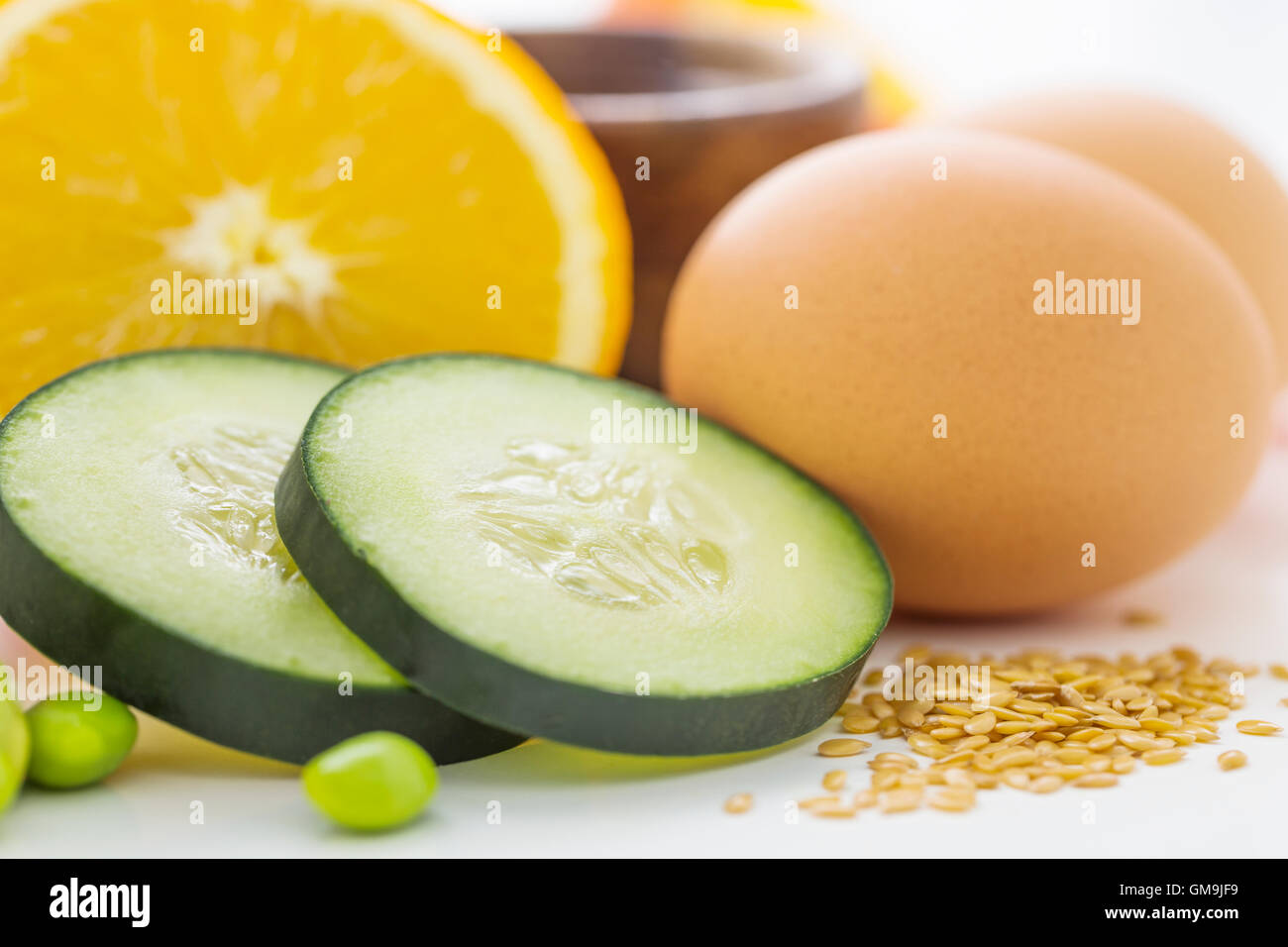 Uova con fette di cetriolo e arancione Foto Stock
