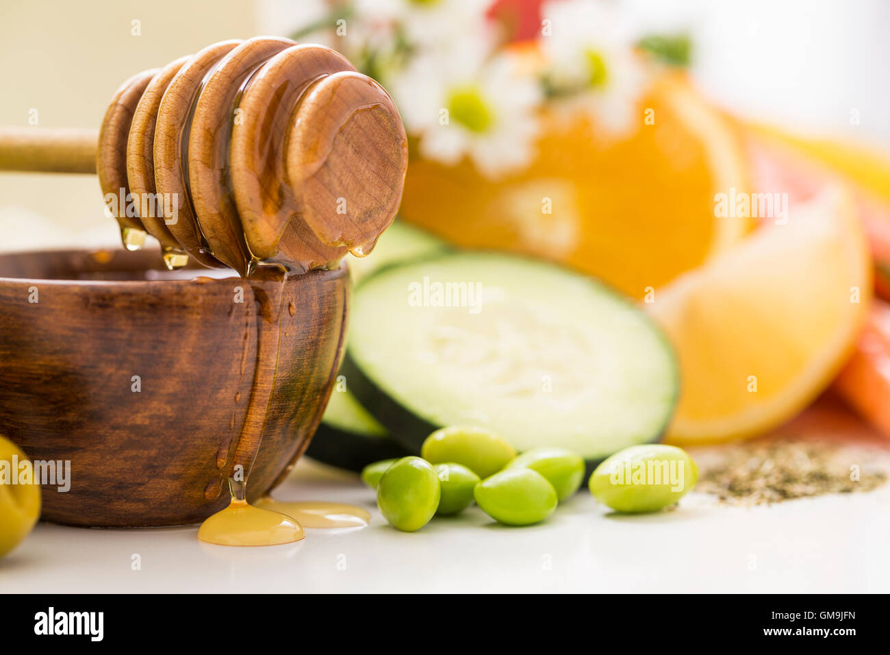 Il miele il bilanciere sulla ciotola con miele e verdure fresche Foto Stock