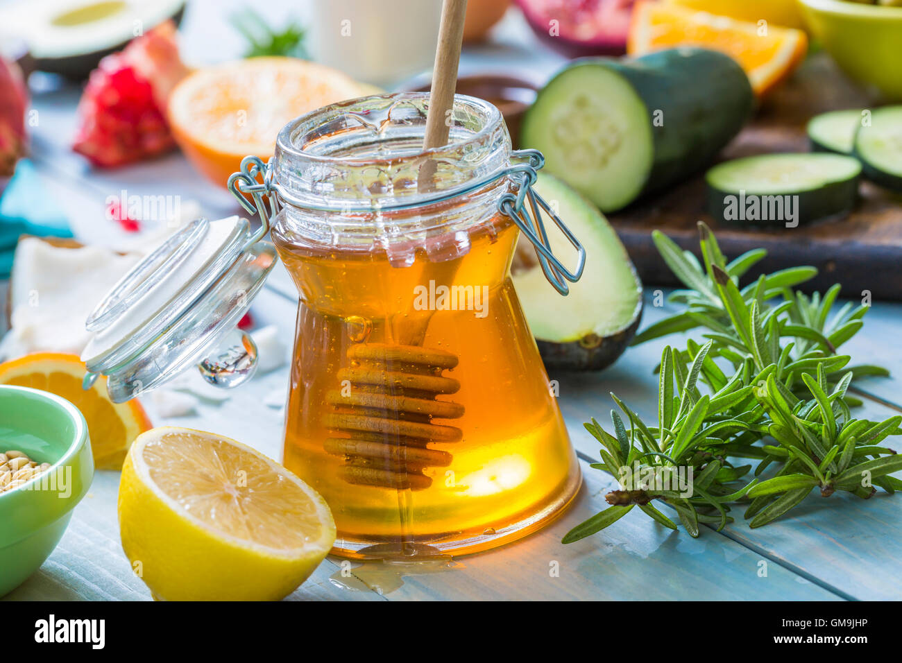 Un vasetto di miele con il bilanciere, limone e le erbe fresche Foto Stock