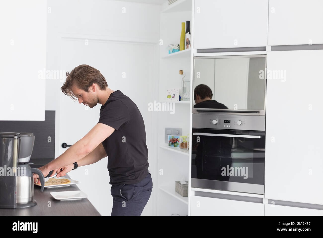 Metà di uomo adulto prepara la colazione in cucina moderna Foto Stock