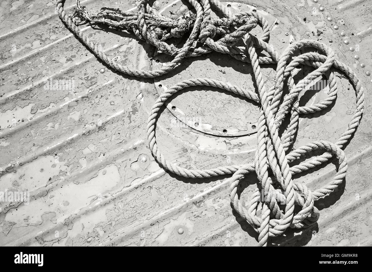 Annodato la cima di ormeggio giacente su una schifezza coperta, vecchio stile di foto in bianco e nero Foto Stock