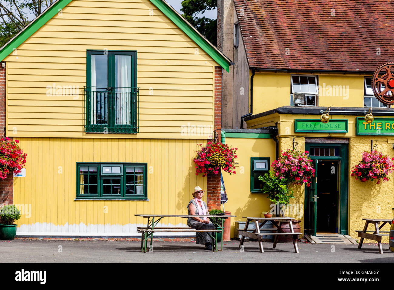 Una donna si siede da solo al di fuori di un Pub di campagna in East Sussex, Regno Unito Foto Stock