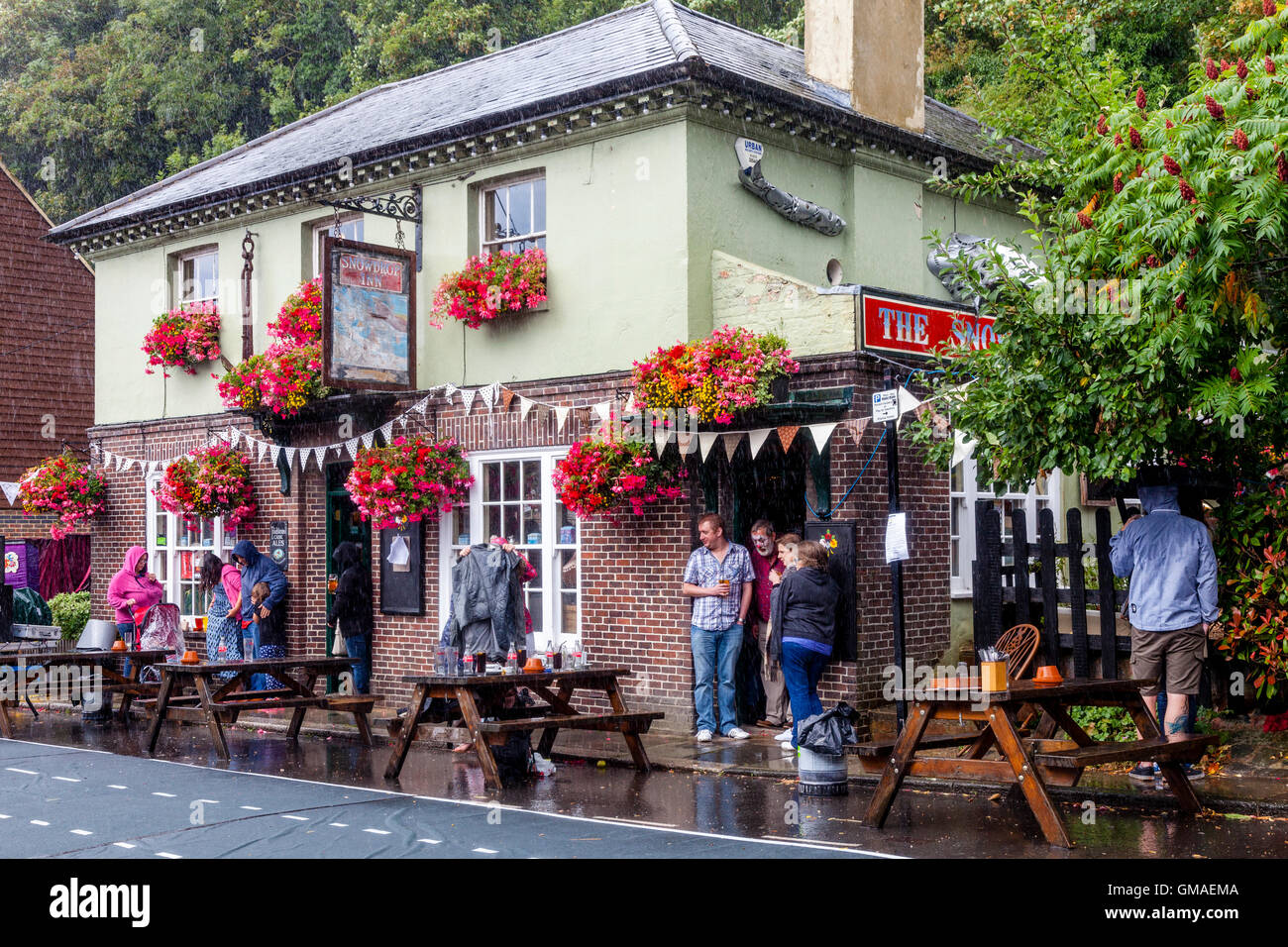 Persone riparo dalla pioggia al di fuori della Snowdrop pub della città mercato di Lewes, East Sussex, Regno Unito Foto Stock