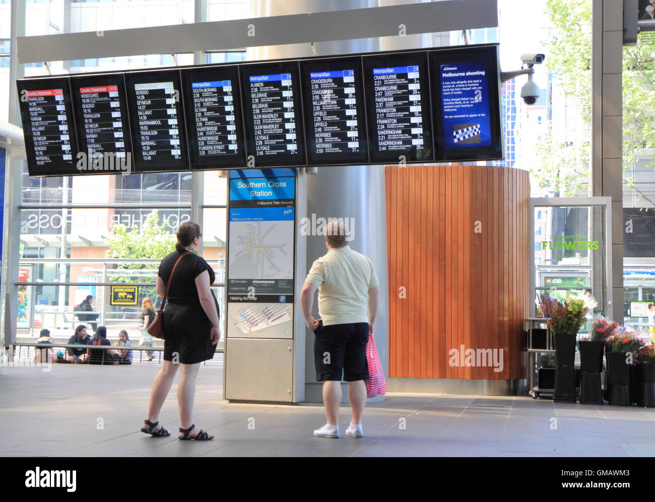 Passeggeri verificare orari presso la Stazione di Southern Cross in Melbourne Australia. Foto Stock