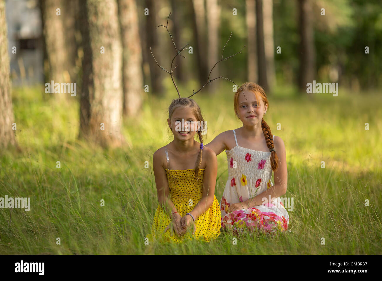 Due divertenti bambine posano per una foto nel parco. Foto Stock