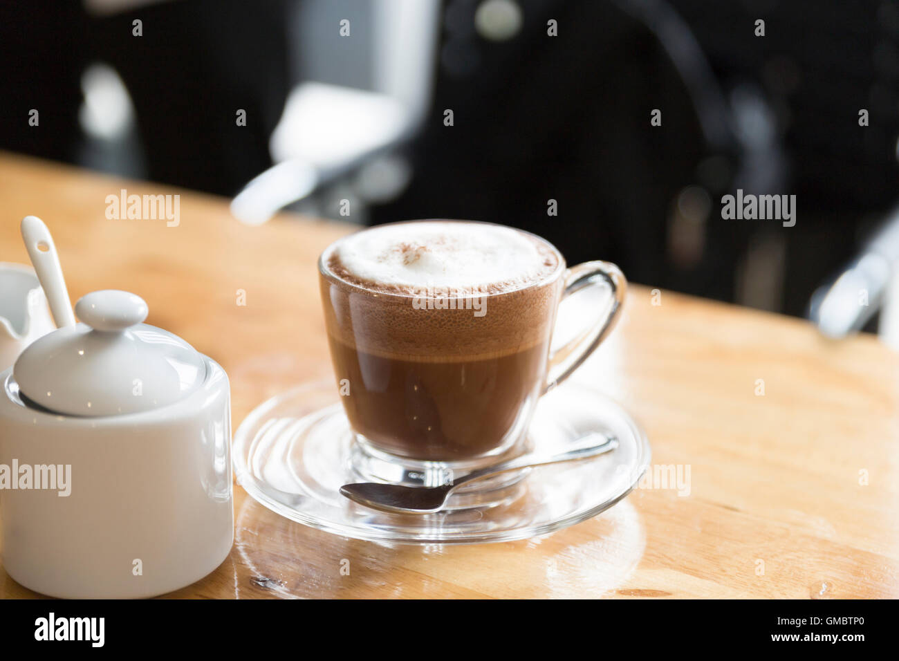 Cioccolata calda bevanda al cioccolato con zucchero e sciroppo mug sulla scrivania in legno Foto Stock
