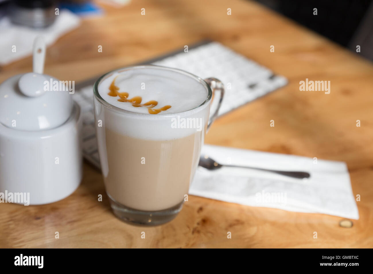 Hot cappuccino bevanda al caffè coppa con tazza di zucchero sulla scrivania in legno Foto Stock