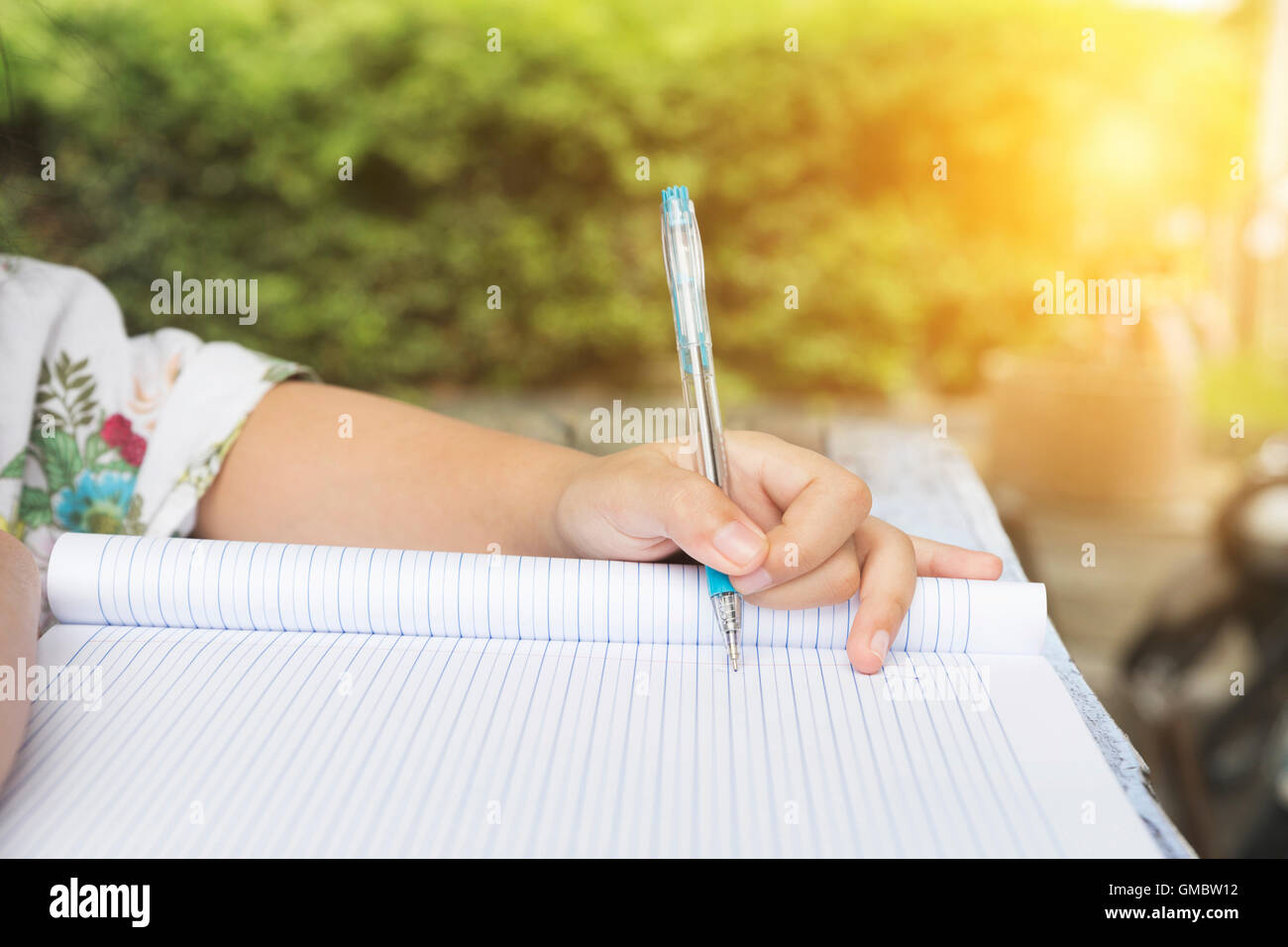 La mano della bambina tenendo pen iscritto su notebook Foto Stock