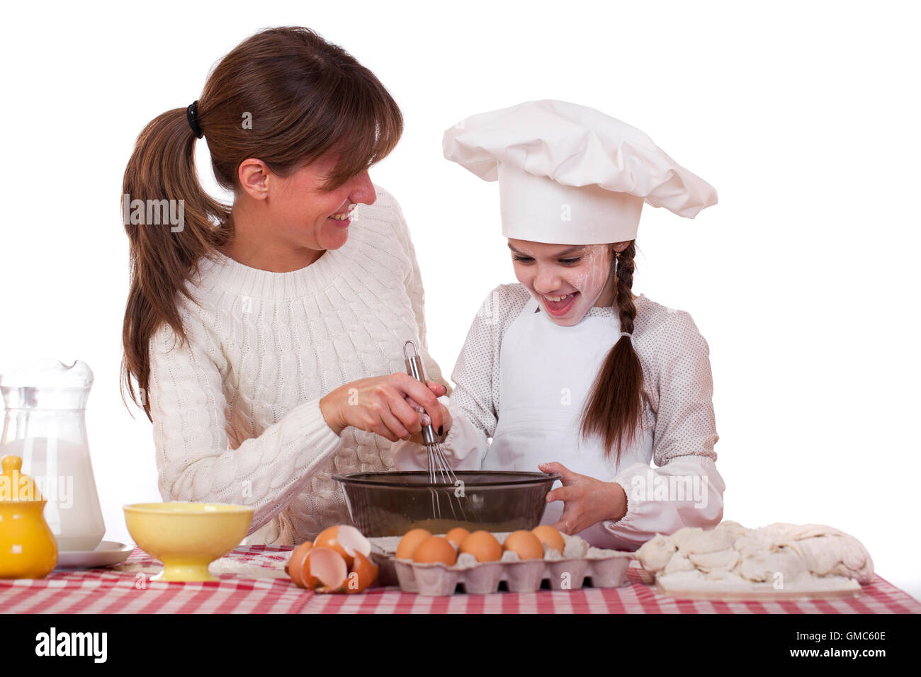 Felice madre con figlia piccola cucina gioiosa, isolato su sfondo bianco Foto Stock