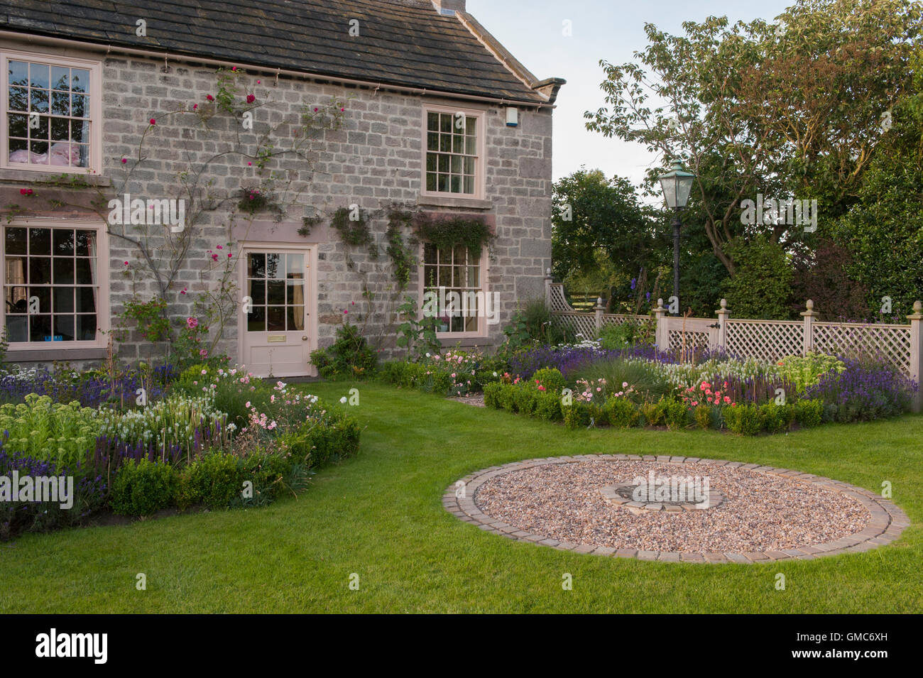 Pavimentazione circolare design e fiori in bella e tradizionale, progettato e paesaggistici, giardino privato - North Yorkshire, Inghilterra. Foto Stock