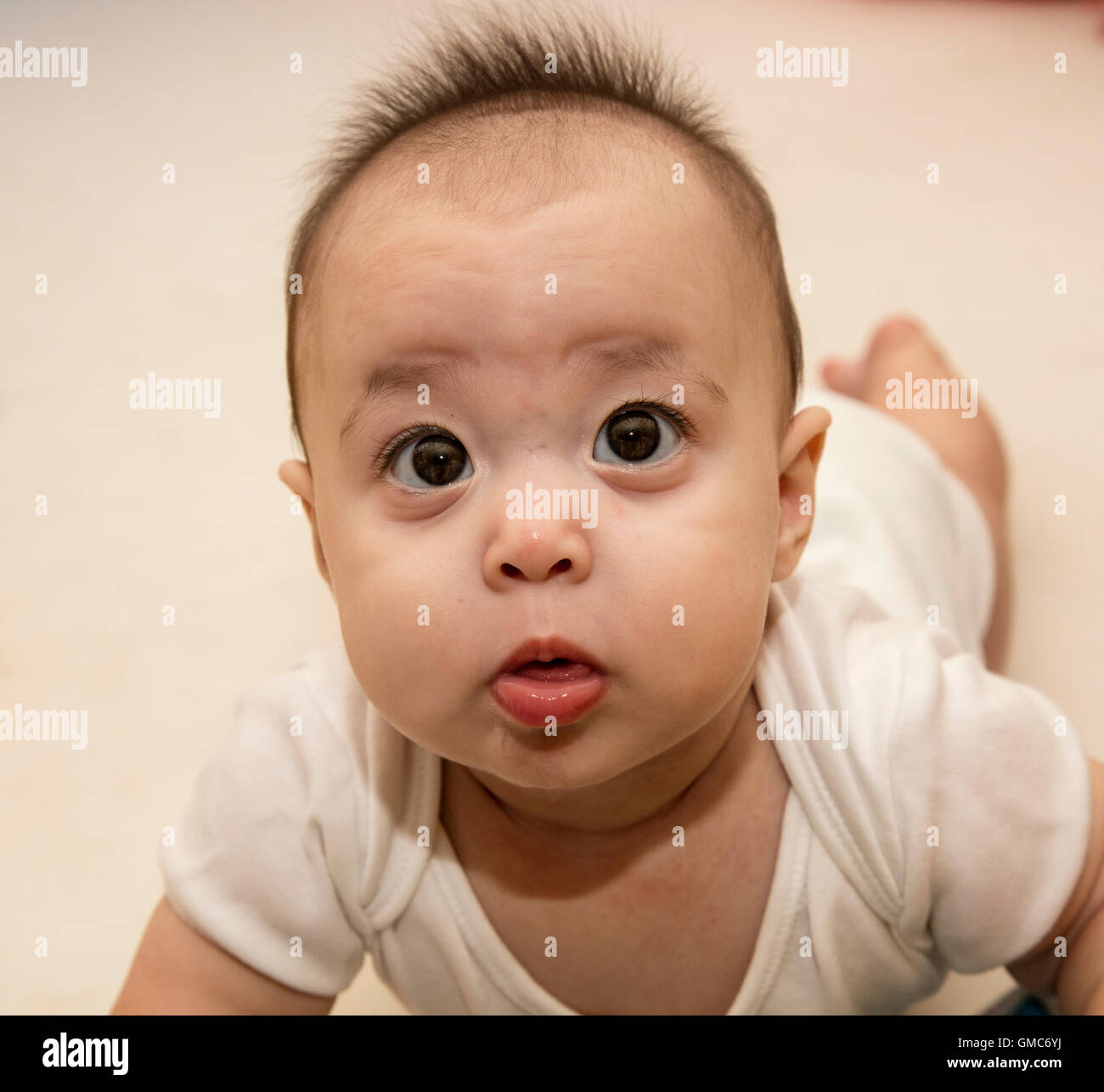 Carino quizzical baby guardando verso l'alto Foto Stock