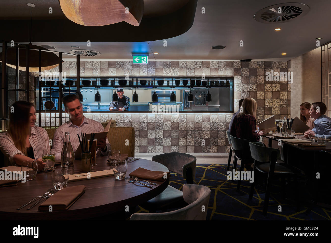 Cucina aperta e ristorante area con posti a sedere. Campbelltown Catholic Club Kyobi Ristorante + Lounge, Sydney, Australia. Architetto: Scott Carver, 2016. Foto Stock