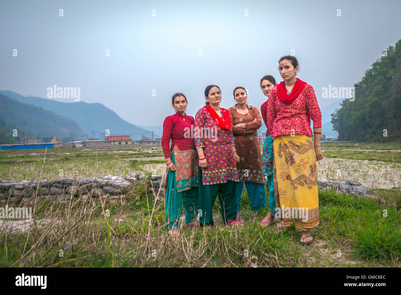 Ritratto di donne, abitanti di Khahare, in quanto si trovano vicino a un muro di gabione sul lato della pianura alluvionale di Harpan Khola a Kaski, Gandaki, Nepal. Foto Stock